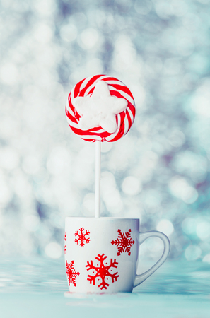 Christmas candy in cup with snowflakes at winter bokeh background, front viewの写真素材