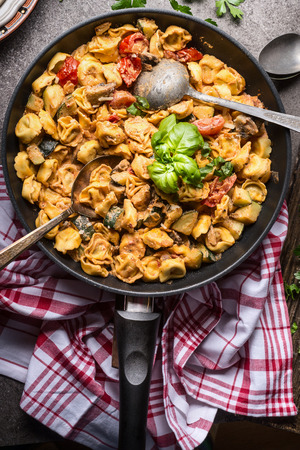 Vegetarian tortellini pot with vegetables sauce and spoons , top view, close up. Healthy cooking and eating. Italian food conceptの写真素材