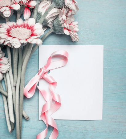 Close up of pretty flowers on turquoise blue shabby chic background and mock up of greeting card with pink ribbon for Mothers day, wedding, Birthday  or happy eventの写真素材