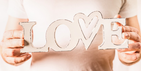 Male hands holding word Love on light background, close upの写真素材