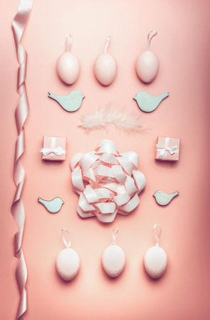 Easter pastel pink composing with eggs,ribbon,bow, birds and feather on table background, top view, flat layの写真素材