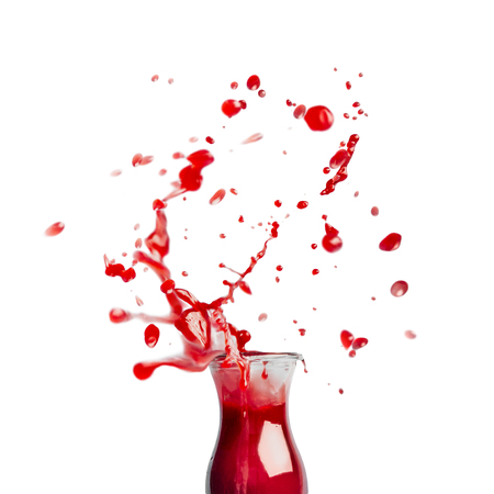 Red juice or smoothie glass bottle with splash,  isolated on white background, front view. Healthy summer beverage conceptの写真素材