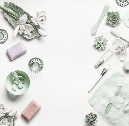 Green cosmetic setting for facial skin care with white orchid flowers, tools and accessories on white background, place for text, frame Beauty and nature herbal cosmetic conceptの写真素材