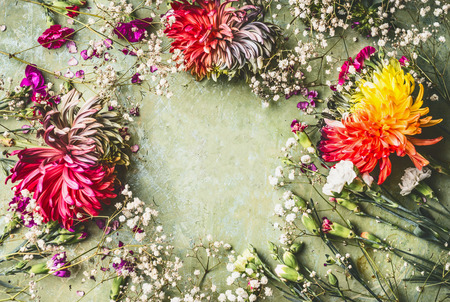Pretty summer garden flowers frame on green background, top viewの写真素材