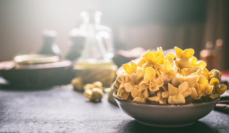 Bowl with fresh homemade tortellini on dark rustic kitchen table , front view. Home cuisineの写真素材