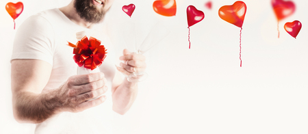 Young man with bottle of champagne and red bow at white with heart ballons , bannerの写真素材