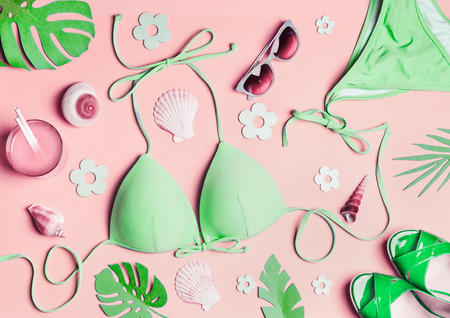 Summer flat lay. Green woman's beach accessories: swimsuit bikini , sandals, drink, sunglasses , sea...