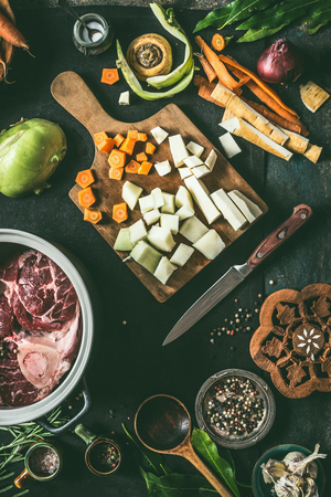 Ingredients for meat dishes recipes on kitchen table background with vegetables , seasoning and kitchen utensils, top view. Flat lay. Broth, meat bone stock or soup cooking preparationの写真素材