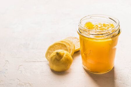 Lemon curd in glass with sliced lemon on white table, side viewの写真素材