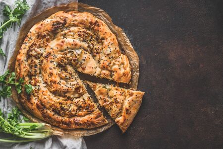 Turkish savory pie with Phyllo dough. Su boregi, burek or borek on dark rustic background. Top view.の写真素材