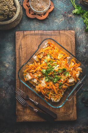 Tasty fish dish with vegetables sauce on kitchen table background with forks. Top view.  Healthy home cooking concept. Homemade cuisineの写真素材