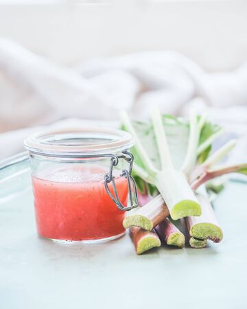 Rhubarb jam or jelly on light table  in sunlight with ingredients.の写真素材