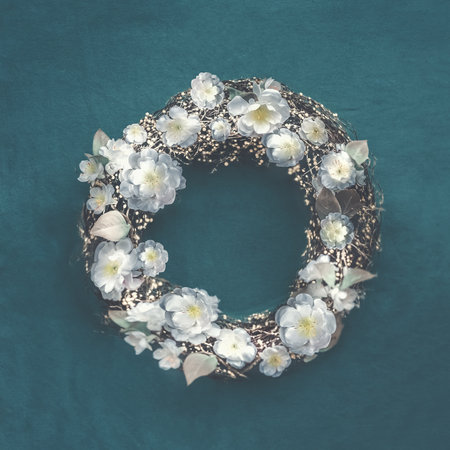 Springtime wreath with white blossom on dark blue background, top viewのeditorial素材