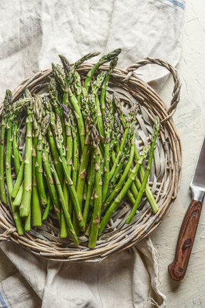 Green raw asparagus on tray with knife, top viewの写真素材