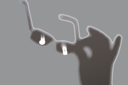 shadow hand holds glasses silhouette gray backgroundの写真素材
