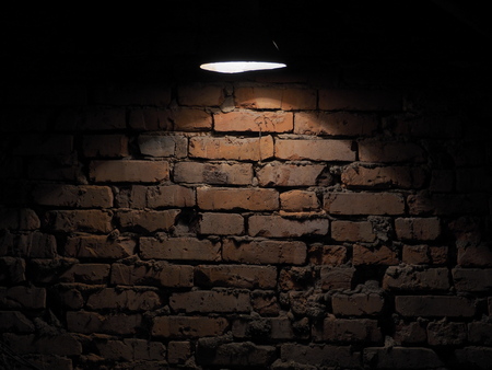 The old brick wall is lit by a flashlightの写真素材
