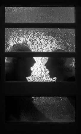 behind the glass silhouettes of two people shouting at each other