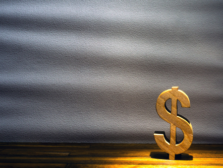 dollar sign made of wood on a gray backgroundの写真素材