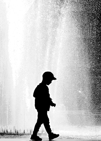 silhouette of a child on a background of a spray fountainの写真素材