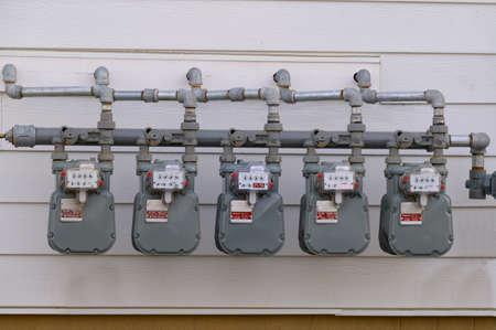 Digital electric meters in a row measuring power use wall power voltagesupplyの写真素材
