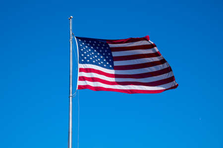 american flag in the wind on blue background color red prideの写真素材
