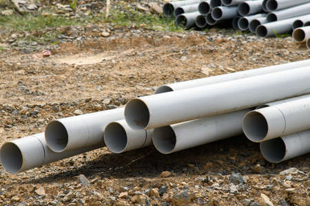 Sewer pipes waiting to be placed into the ditch at construction site water tube supply new