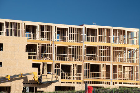 Apartment building under construction on sunny day on blue sky background plywood new complex