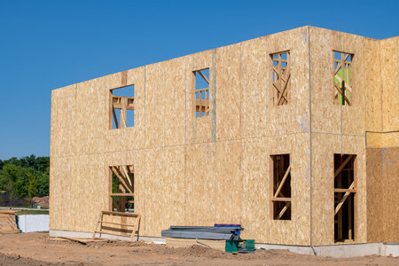 construction of a new plywood house against the blue sky wood framework wall real site window real...