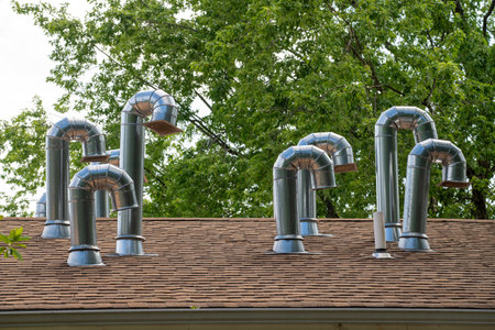 zinced stovepipe on house roof close up view against the blue sky background isolated iron roofing topの写真素材