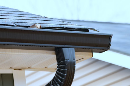 rain gutter of roof with downpipe new metal pipe corner rooftop siding