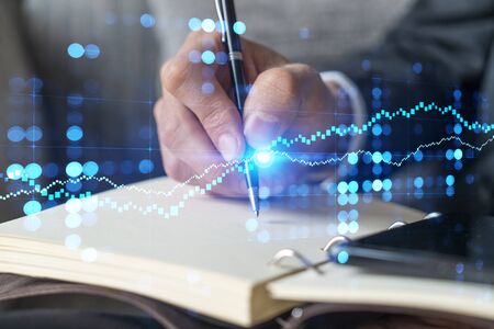 Double exposure of man taking notes from phone and financial chart. Success concept. Formal wear.