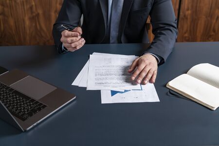 A man broker signing the mortgage contract at the real property agent office. The concept of entering into legal power to take liabilities.の写真素材