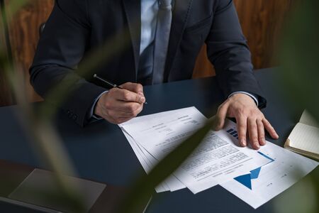 A man broker signing the mortgage contract at the real property agent office. The concept of...