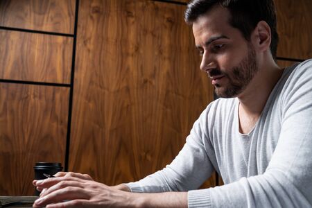 A handsome man in office typing the contract on laptop. The concept of searching internet. Casual...