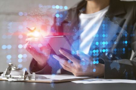 Double exposure of businesswoman typing phone taking notes background and world map hologram....