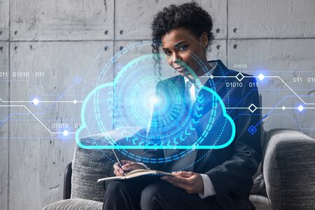 Businesswoman typing on laptop work in modern office on new project. Cloud tech drawing hologram. Double exposure. Concept of success.の写真素材