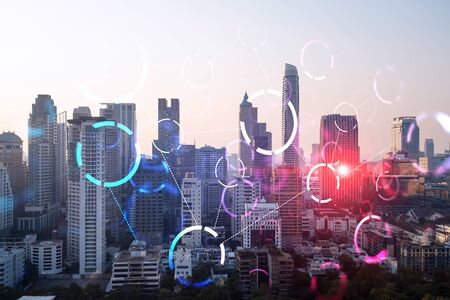 Hologram of abstract technology glowing icons, panoramic cityscape of Bangkok at sunset, Asia. The concept of worlds technological changes. Double exposure.の写真素材