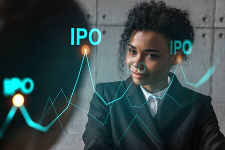 Two businesswomen work together in modern office on new project. Double exposure. Concept of success. IPO symbol icon.の写真素材