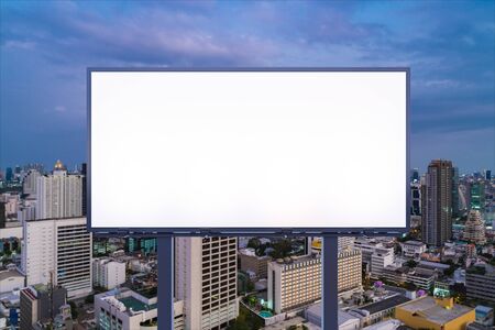 Blank white road billboard with Bangkok cityscape background at night time. Street advertising poster, mock up, 3D rendering. Front view. The concept of marketing communication to promote idea.の写真素材