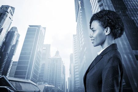 Successful smiling black African American business woman in suit. Singapore cityscape. The concept of woman in business. Legal consultant. Double exposure.の写真素材