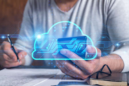 Double exposure of man signing contract with phone and cloud hologram drawings. Concept of big data center.の写真素材