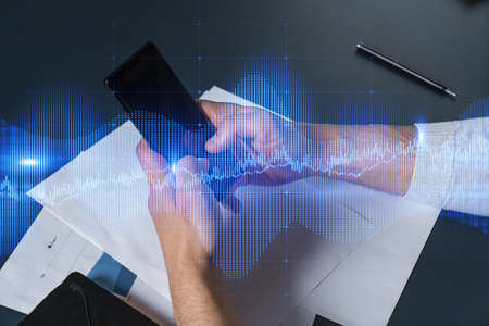 Man using phone. Hands typing smartphone. Double exposure with forex graph hologram. Close up....