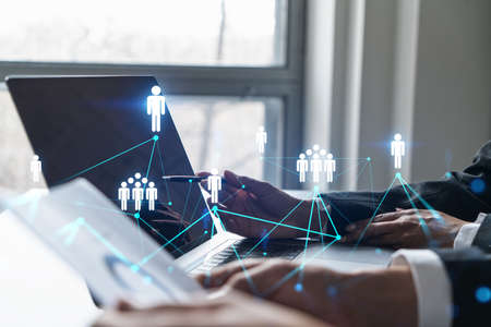 Man and woman working together on social media project. Blue infographic of people network hologram. Concept of teamwork. Multiexposure.の写真素材