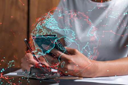 Planet earth world map hologram and a woman signing contract use phone. Multiexposure.の写真素材