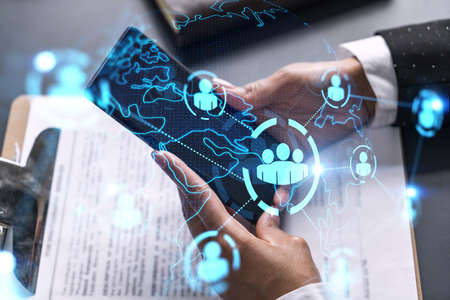 Businesswoman using smart phone in office. Social media icon hologram. Business network concept....