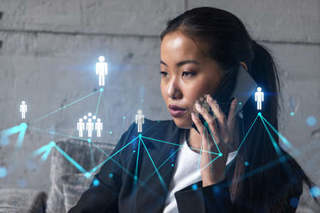 Businesswoman speaks phone and social network hologram. Double exposure.の写真素材