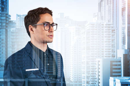 Young handsome businessman in suit and glasses dreaming about new career opportunities after MBA...