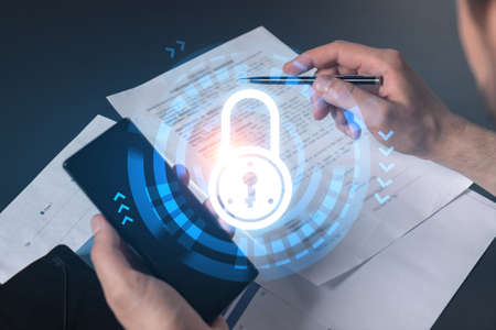 Double exposure of man signing contract with phone and lock icon hologram. Concept of securitization...