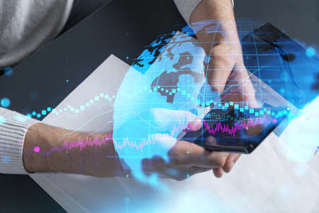 Man typing phone background and financial chart drawing. Multiexposure.の写真素材