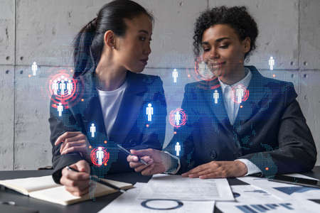 Two businesswomen work together in modern office on new project. Double exposure. Concept of...